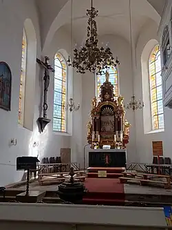 Chorraum mit dem histor. Kron­leuchter, Chor­fenstern, Kruzifix, Kanzel