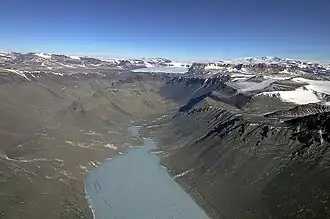 Blick nach Westen im oberen Abschnitt des Wright Valley mit dem Vandasee (Vordergrund) und der Olympus Range (rechts)
