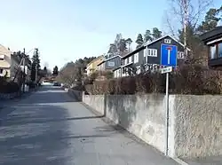 Foto einer Straße, gesäumt von Häusern mit Garten