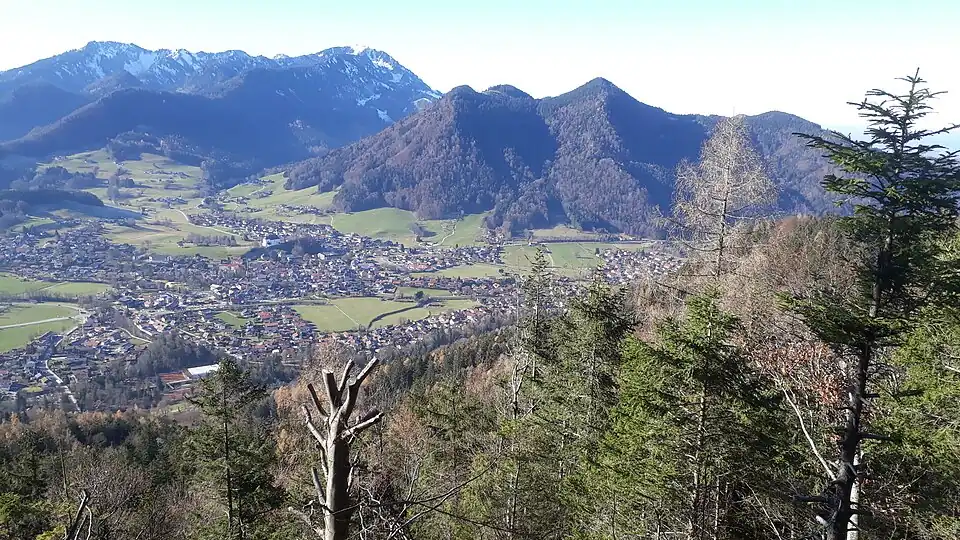 Blick vom Gipfel des Zeller Bergs nach Westnordwesten. In der Mitte der Westerberg mit Platte, rechts anschließend der Haargaßberg, im Hintergrund links der Hochfelln.