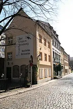 Das Bild zeigt ein beigefarbenes Haus von der Seite.