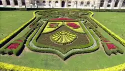 Farbfotografie von einem Blumenbeet, das nach dem Wappen des Papstes arrangiert wurde.