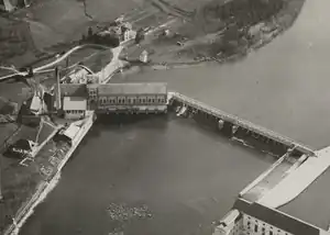 Links Maschinenhaus mit angebautem Kesselhaus, Wehr mit Grundablass in der Mitte und Flossrampe rechts. Aufnahme ca. 1925 von Walter Mittelholzer